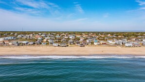 A coastal residential area with houses along the beach, a clear sky, and calm sea. - SEMI OCEANFRONT, Steps to the Beach, Unobstructed Amazing Ocean Views. Remodeled (Kitty Hawk)