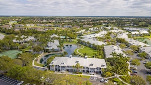 A resort with multiple buildings, a central water feature, and surrounding greenery.