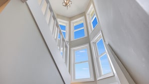 A view of a staircase with multiple windows leading to an upper floor. - Cute Family Beach Home in Wild Dunes Resort; Close to the Beach w/Porch Swing & Community Pool! (Isle Of Palms)