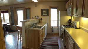 A compact kitchen with wooden cabinets, a built-in stove, and a sink.