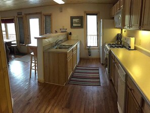 Kitchen area with sink, stove, refrigerator, and central island.