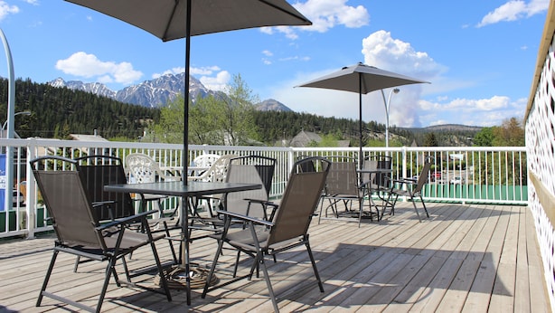 A deck with outdoor furniture and a view of mountains. - Downtown Jasper Suite Beautiful Views (Jasper)