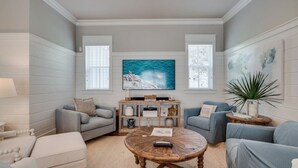 Ein Wohnzimmer mit Kamin, zwei Sofas, einem Couchtisch und einem großen Gemälde an der Wand.