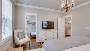 A bedroom with a bed, a TV, a chair, a dresser, and a closet. - Luxury 4BR Home! Walk to Beach & Bike to Pool! ~ The Wander Inn at WaterSound (Santa Rosa Beach)