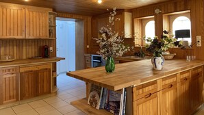 A wooden kitchen with a central island, wooden cabinets, and a tiled floor. - wood-panelled sailor's cottage a stone's throw from the port (Bénodet)