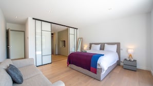 Un dormitorio moderno con una cama grande, un sofá y un vestidor.