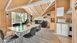 Un intérieur de chalet chaleureux comprenant un coin repas, une cuisine et un espace salon.