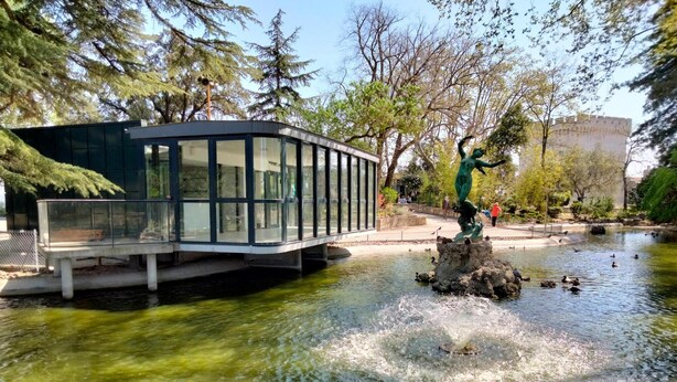 A glass-enclosed structure with a viewing platform over a body of water, surrounded by trees and a statue. - Amazing home in Mornas (Mornas)