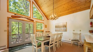 A dining area with a wooden ceiling, large windows, and a chandelier. - Dockside Dog Friendly Retreat w/ Views & Arcades (Swanton)