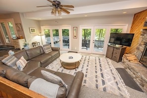 A living room with a brown leather sofa, a round coffee table, and a television.