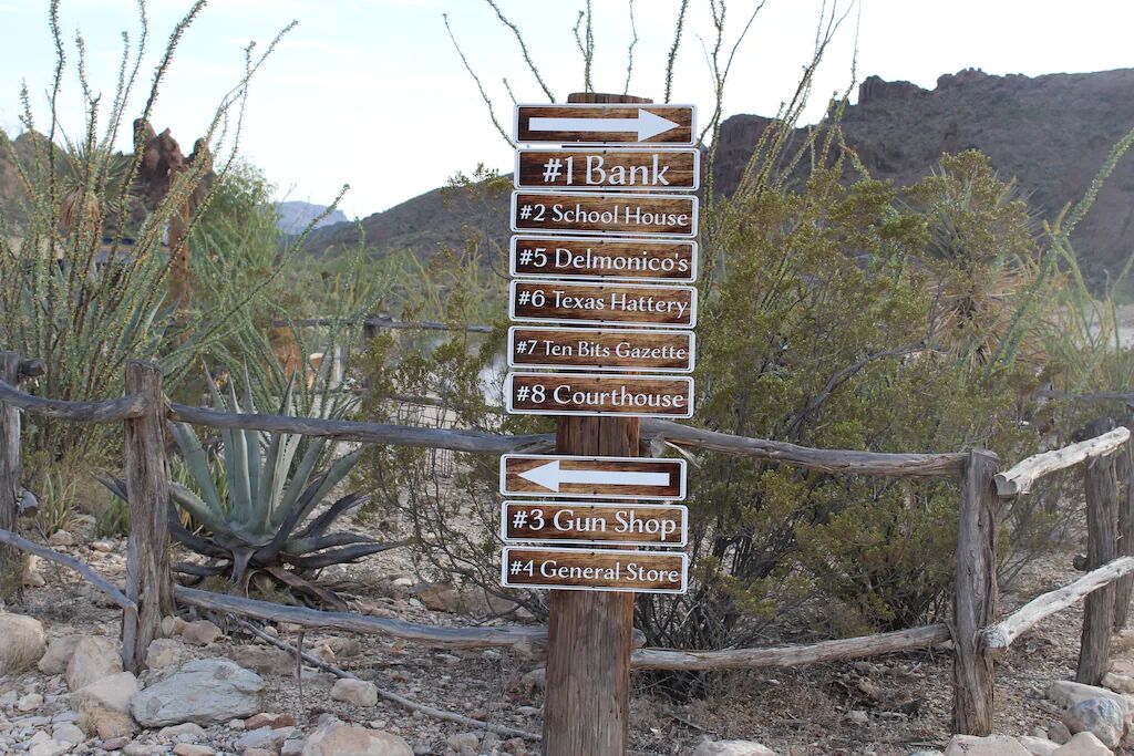 A directional signpost with multiple arrows pointing to various local businesses.