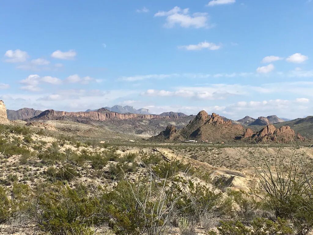 A desert landscape with sparse vegetation and rocky terrain.