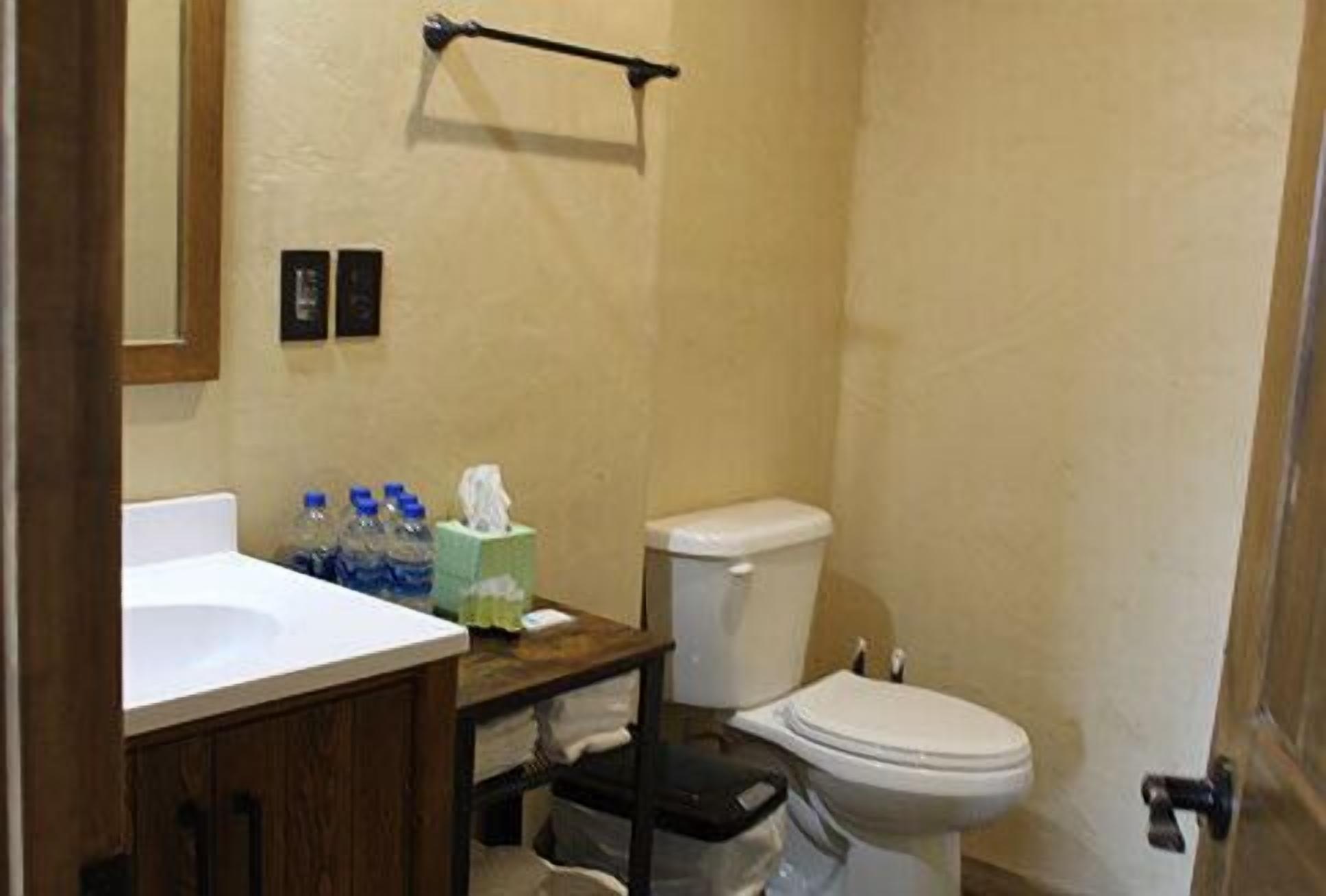 A bathroom with a sink, toilet, and a towel rack.