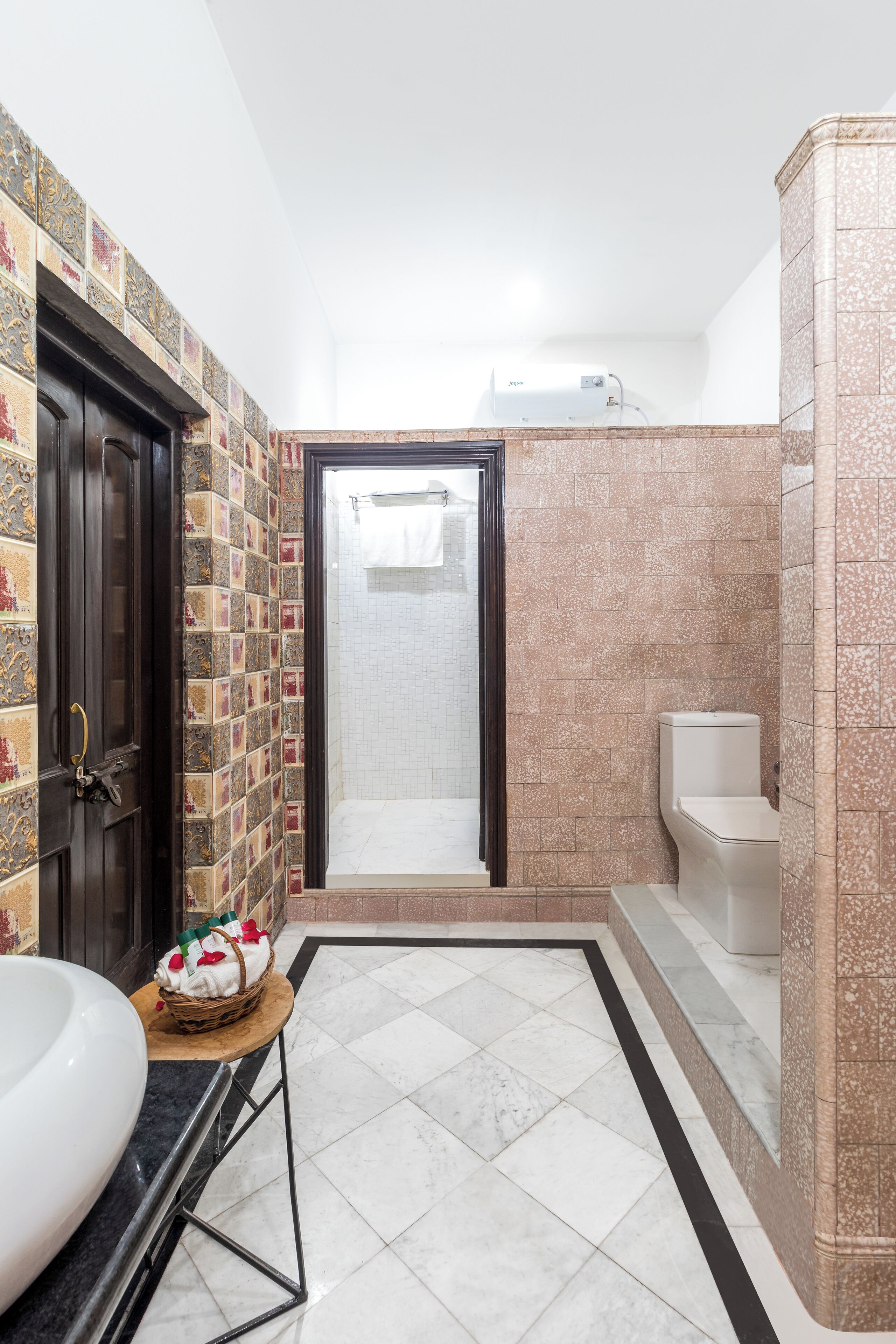 A bathroom with a tiled floor, a sink, a toilet, and a shower area.