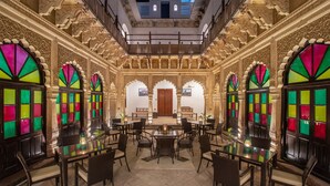 Un comedor amplio con arcos ornamentados y una disposición central de asientos.