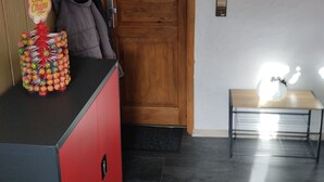 A reception area with a wooden door, a welcome sign, a vending machine, and a small table with lights. - Ferienwohnung "Am Vulkanpfad" (Ettringen)