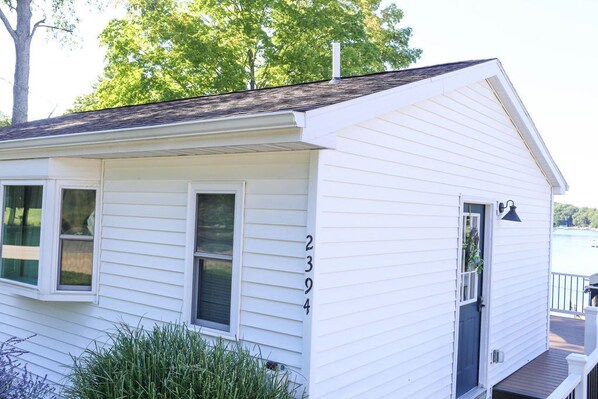 A white single-story house with a number 2394 on the side, a front door, and a small porch. - Spectacular Lake Views~7 mi to Hospital~Peaceful Retreat (Stanton)