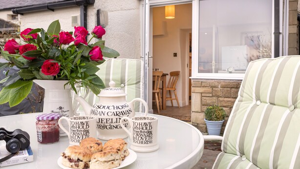 A table with a white pitcher, two mugs, a plate of scones, and a camera. - Ingleton 2-bed Cottage, Sleeps 4, Pet Ok & Parking (Carnforth)