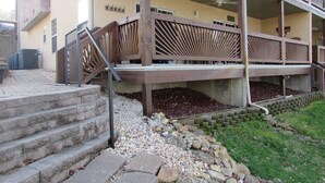 Ein mehrstöckiges Gebäude mit überdachtem Außenbereich, Steintreppe und Holzgeländer.