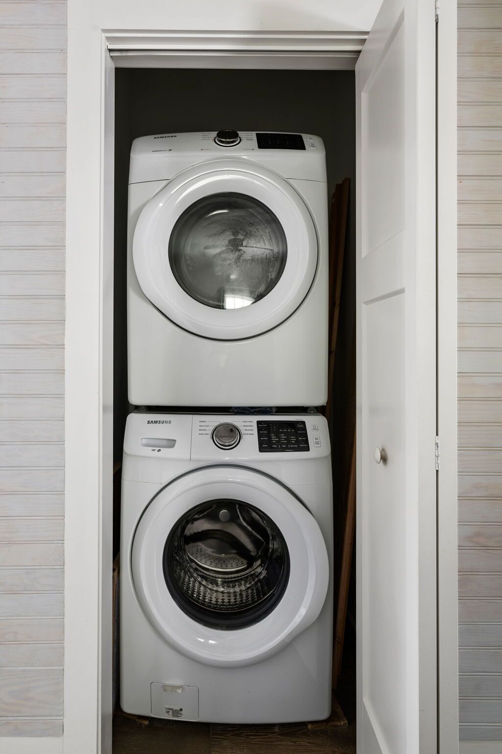 A laundry room with two stacked washing machines.