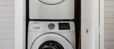 A laundry room with two stacked washing machines.