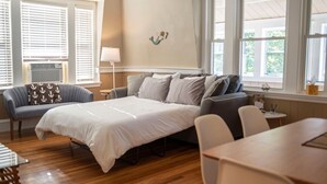 A bedroom with a bed, a sofa, a dining table, and a lamp. - Home Away from Home | Next to Boston & Beach, EV+ (Quincy)