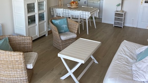 A compact living space with a dining area, kitchenette, and seating arrangements. - Appartement Front de Mer Dans une Résidence de Prestige (NEUFCHATEL HARDELOT)