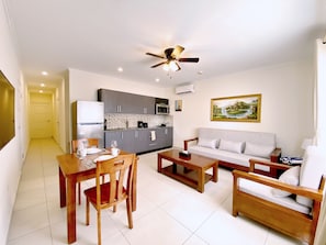 Cozy living space with a kitchenette, dining area, and seating area featuring a sofa and coffee table.