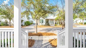 A white house with a porch, surrounded by trees and a clear sky. - Golf Cart｜4bed, 3.5 bath｜Luxury 30A Getaway! (Santa Rosa Beach)