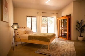 Cozy retreat with a single bed, floor lamp, and potted plant.