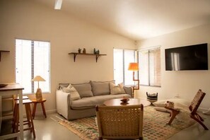 Relax in this stylish living room with a sofa set, dining table, and flat-screen TV.