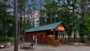 A rustic cabin with a porch, a fire pit, and a picnic table. - Beautiful cabins with a pool in a peaceful setting (Broken Bow)