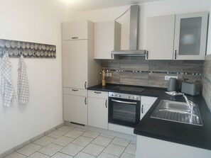 Een koelkast, een oven, een kookplaat, een vaatwasser