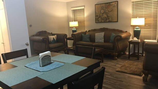 A living room with a dining table, two sofas, and a coffee table. - Cozy Modern 1 Bed 1 Bath next to Park! (Van)