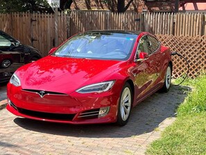 A red Tesla parked on a brick driveway. - Quiet Street by Georgetown & GWU, Free Parking + EV Charger (Washington)