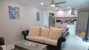 A living room with a sofa, coffee table, and artwork on the wall. - Escape to the Beach (Treasure Cay, North Abaco)