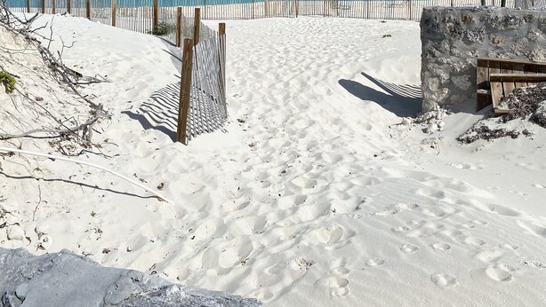 A sandy beach with a wooden fence and a stone wall. - Escape to the Beach (Treasure Cay, North Abaco)