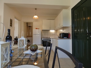 Enjoy cooking in this well-equipped kitchen with a central island, refrigerator, microwave, and stove.