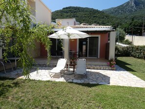 Relax on the patio with comfortable lounge chairs and a shaded table.