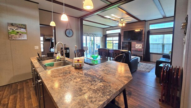 A modern kitchen with granite countertops, pendant lighting, and a dining area with a large table and chairs.