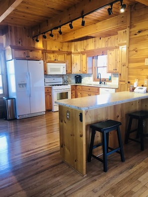Enjoy cooking in this well-equipped kitchen with a central island, stainless steel appliances, and comfortable seating for two.