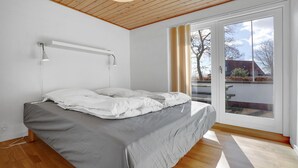 Et soveværelse med en seng, loftslampe, et vindue og udsigt ud