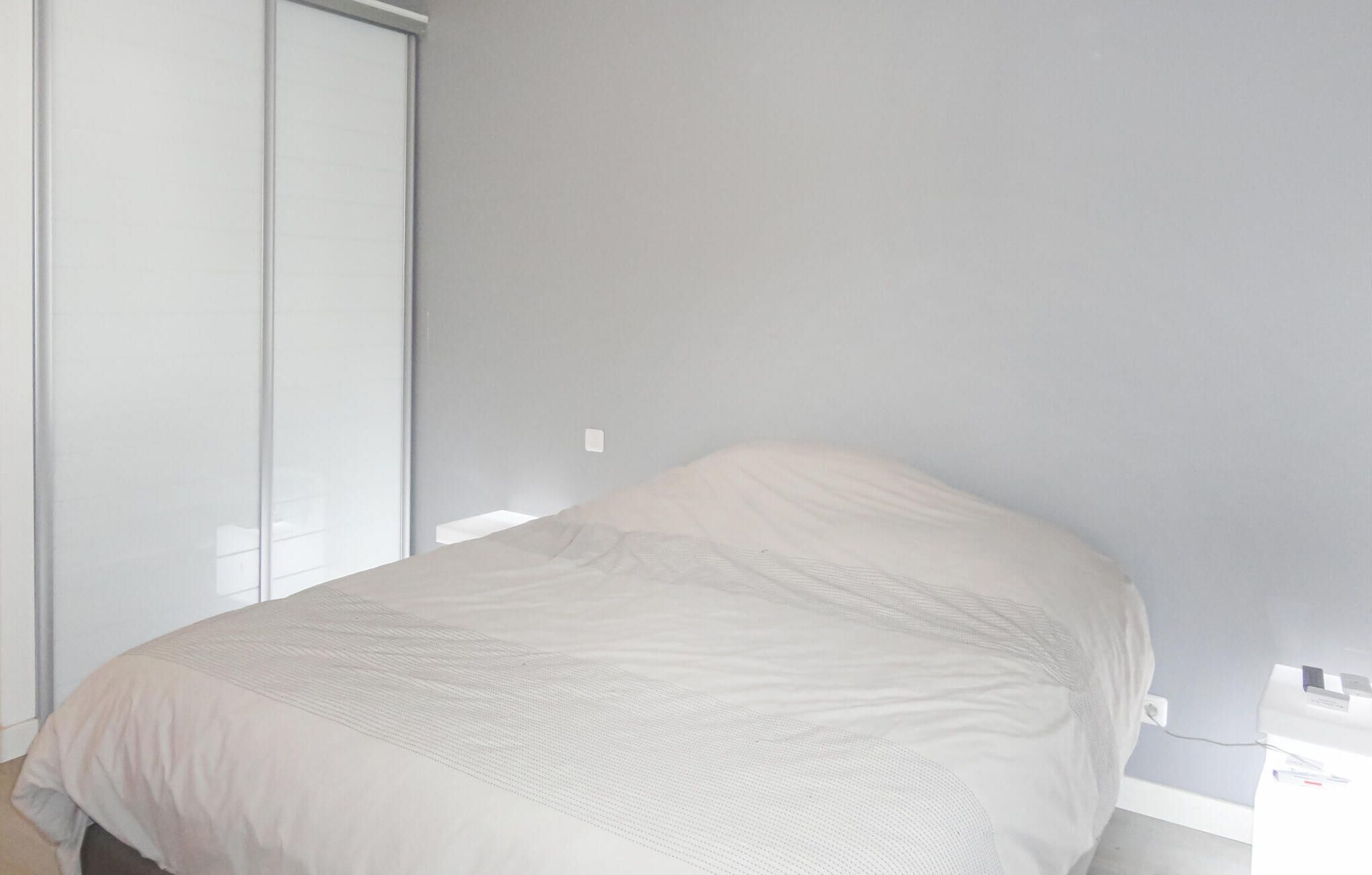 Una camera da letto con un letto, un armadio e una finestra.
