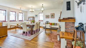 Un salon spacieux avec un coin repas, un plancher en bois et une cheminée.