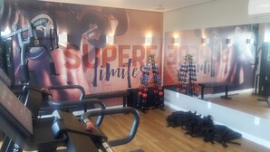Academia com equipamentos de ginástica, um espelho e um pinheiro de Natal.