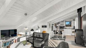 Een moderne woonkamer met een leren bank, een witte salontafel en een televisie.