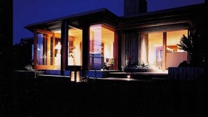 Een modern huis met grote glasramen en een goed verlicht interieur.