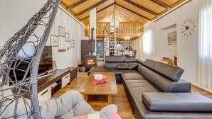 Ein gemütliches Wohnzimmer mit Holzboden, einer Couch, einem Couchtisch und einem Kamin.