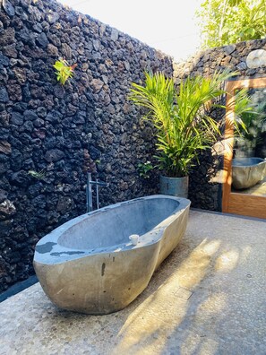 A concrete bathtub in a spa area with a stone wall and potted plants. - Lux family-friendly. Steps to beaches, restaurants & shopping. (Kihei)