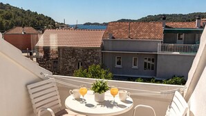 Ein Balkon mit Tisch, zwei Stühlen und einem Blumentopf.